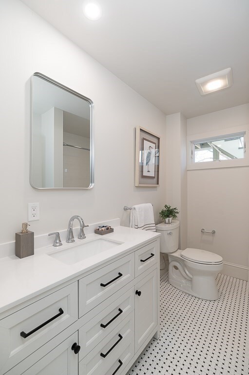 bathroom featuring a shower, vanity, and toilet