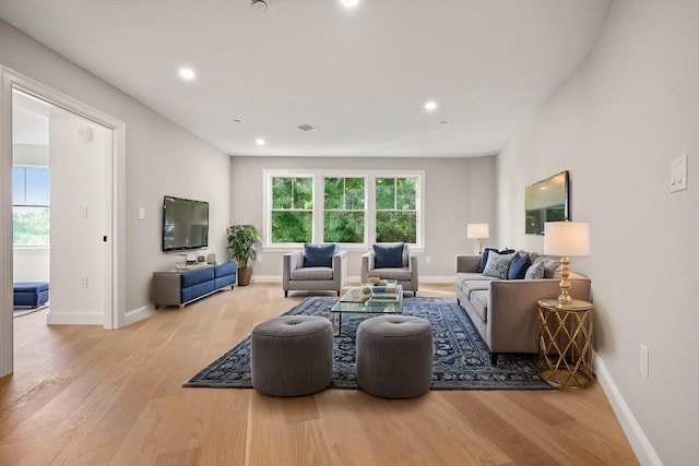 living room featuring light wood-style flooring, recessed lighting, visible vents, and baseboards