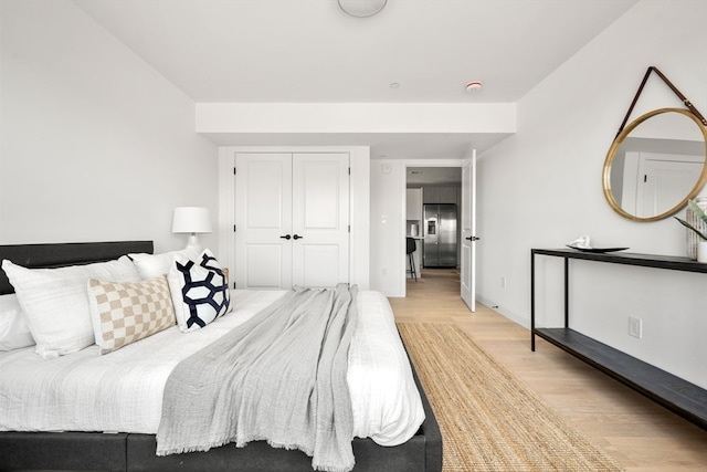 bedroom with light wood-type flooring and a closet