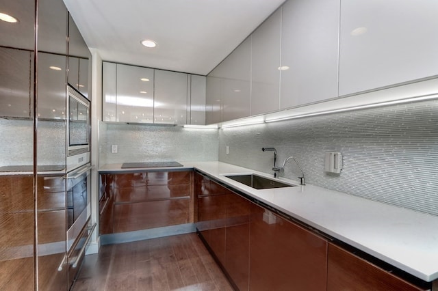 kitchen featuring dark hardwood / wood-style flooring, stainless steel appliances, backsplash, and sink