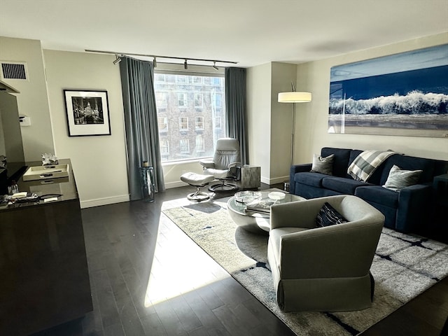 living room featuring dark hardwood / wood-style flooring and rail lighting