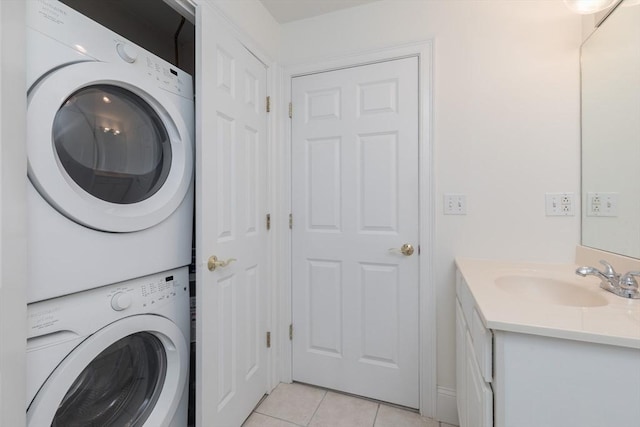 clothes washing area with laundry area, stacked washer / dryer, light tile patterned floors, and a sink