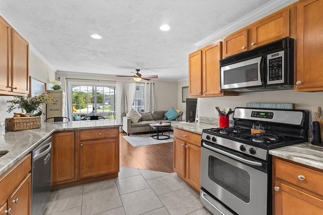 10 Sprucewood Ln Unit 10, Worcester, MA 01606 - kitchen featuring appliances with stainless steel finishes, ornamental molding, brown cabinetry, a ceiling fan, and open floor plan