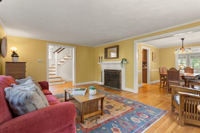 94 Laurel Dr, Needham, MA 02492 - living room featuring light wood-type flooring, stairs, ornamental molding, and a brick fireplace