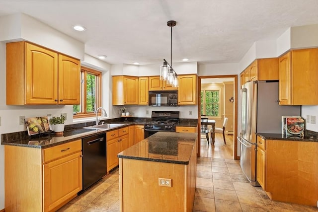 kitchen with black appliances, a sink, dark stone countertops, a center island, and hanging light fixtures