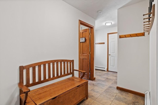 hall with a baseboard heating unit and baseboards