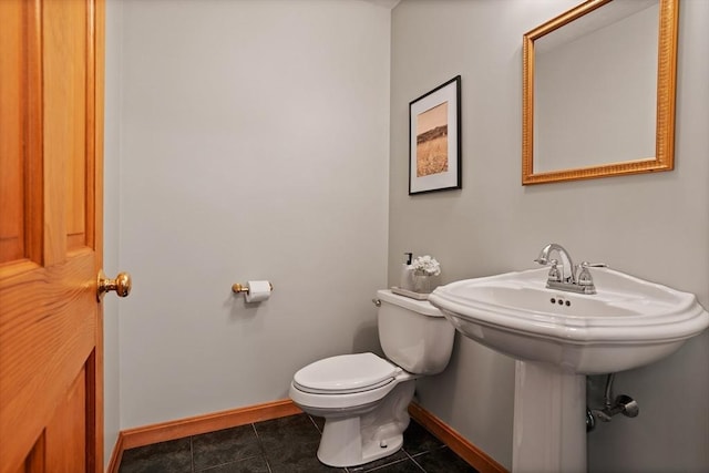 half bathroom featuring toilet, baseboards, and tile patterned flooring