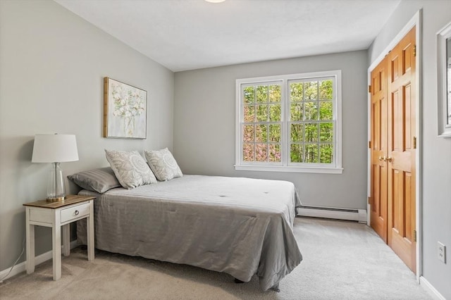carpeted bedroom with a baseboard heating unit and baseboards