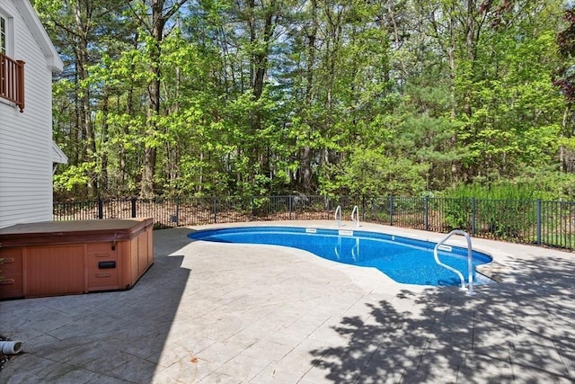 view of swimming pool featuring a hot tub, a patio area, and a fenced backyard