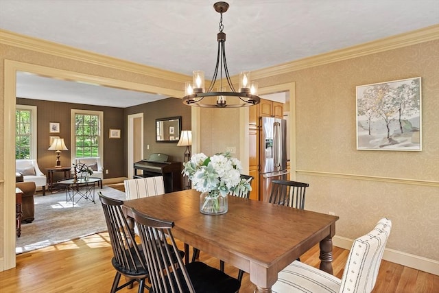 dining space with light wood-style floors, a chandelier, baseboards, and wallpapered walls