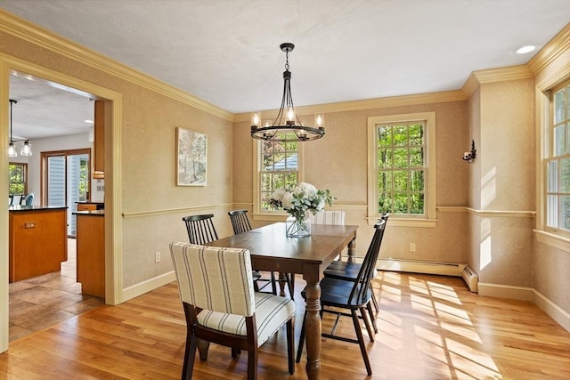 dining area with plenty of natural light, a chandelier, light wood-style flooring, and ornamental molding