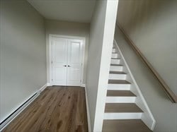 stairs featuring a baseboard radiator and dark hardwood / wood-style flooring