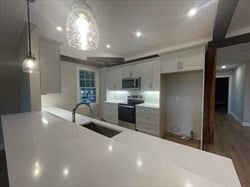 kitchen featuring stainless steel appliances, hanging light fixtures, hardwood / wood-style floors, sink, and kitchen peninsula