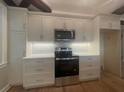 kitchen with white cabinetry, hardwood / wood-style floors, and range with electric cooktop