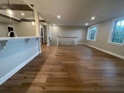 unfurnished living room featuring radiator heating unit and hardwood / wood-style floors