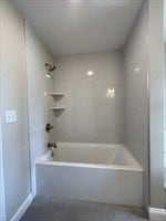 bathroom featuring tiled shower / bath and tile patterned flooring