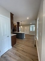 kitchen featuring a center island, pendant lighting, wood-type flooring, and dark brown cabinets