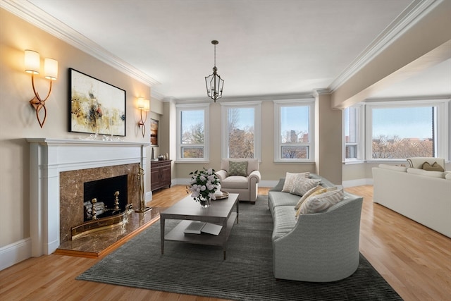 living room featuring light hardwood / wood-style flooring, a high end fireplace, and a wealth of natural light