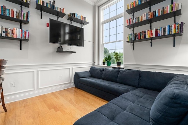 215 Harvard St Unit 40, Medford, MA 02155 - living room featuring wood finished floors, ornamental molding, a decorative wall, and a wainscoted wall