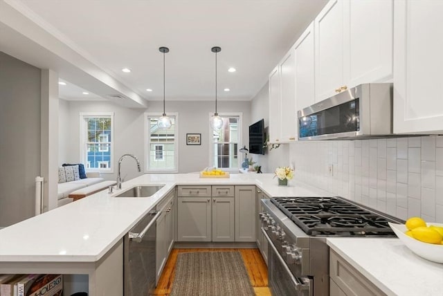 7 Trenton St Unit 2, Boston, MA 02129 - kitchen featuring a sink, stainless steel appliances, a peninsula, light wood-style floors, and light countertops