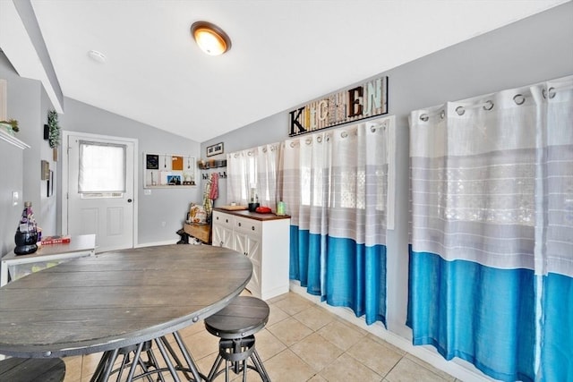 tiled dining room with vaulted ceiling