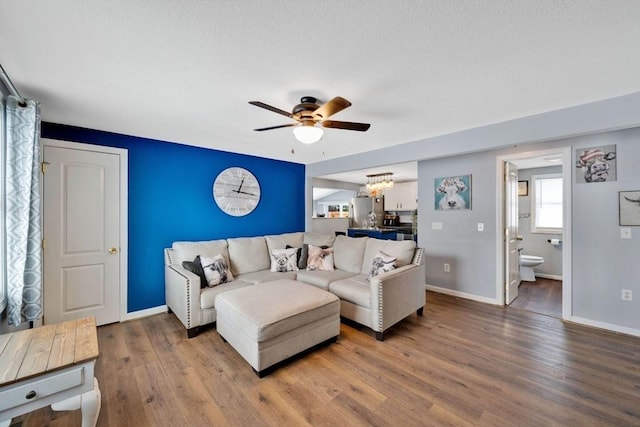 living room featuring hardwood / wood-style flooring and ceiling fan with notable chandelier