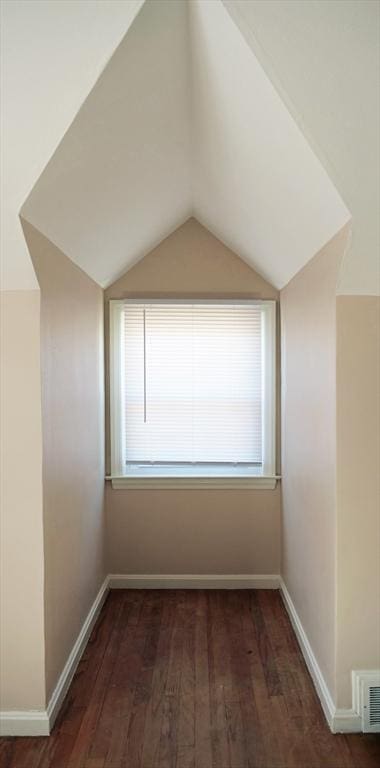 unfurnished room featuring visible vents, wood finished floors, and lofted ceiling