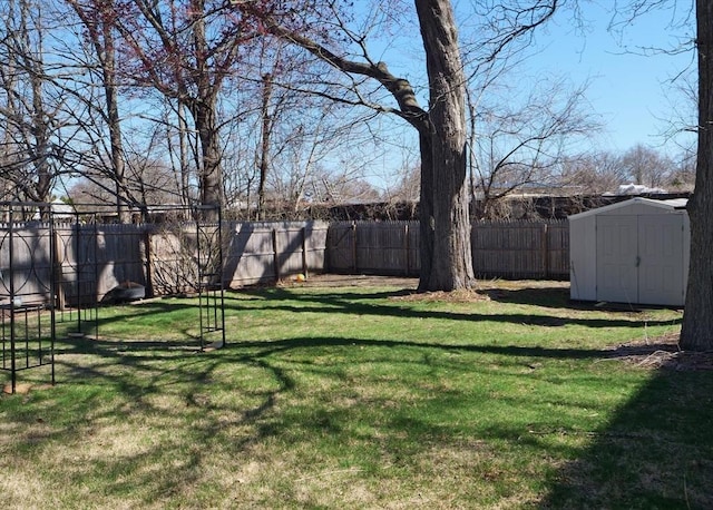 view of yard featuring a fenced backyard, a storage unit, and an outdoor structure