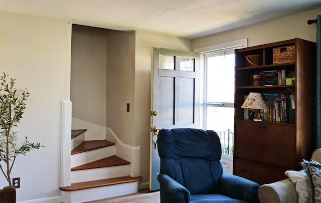 sitting room featuring baseboards and stairway