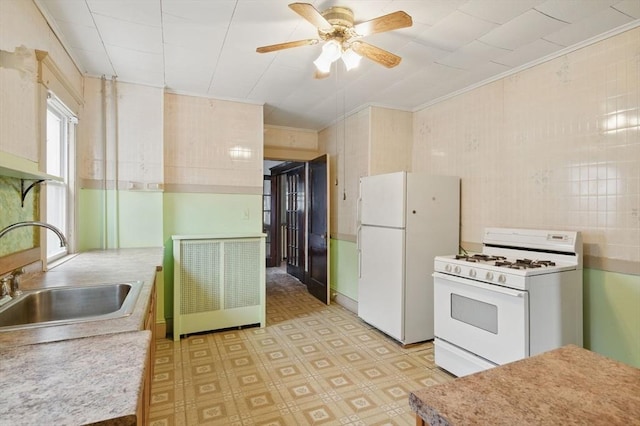 kitchen featuring crown molding, light floors, light countertops, a sink, and white appliances