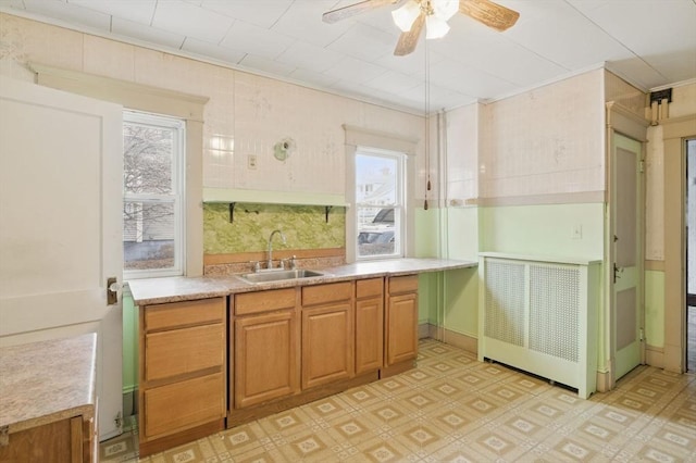 kitchen with light countertops, light floors, a sink, and brown cabinets