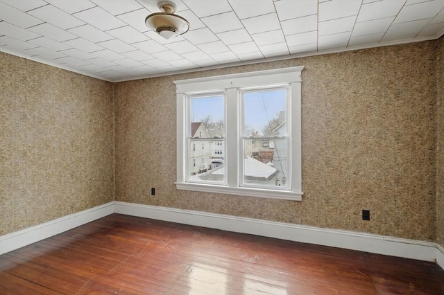 empty room featuring baseboards and hardwood / wood-style floors