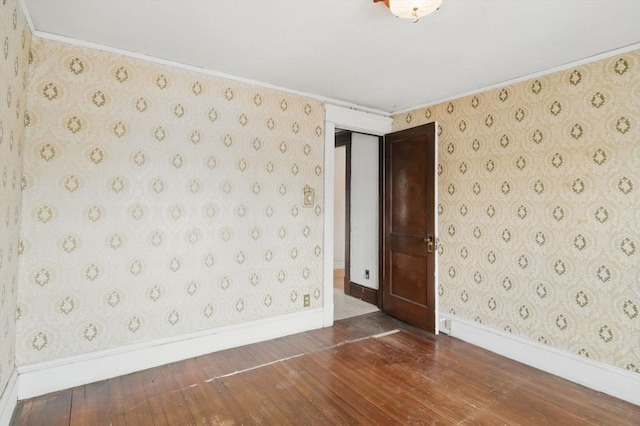 spare room with baseboards, hardwood / wood-style flooring, and wallpapered walls