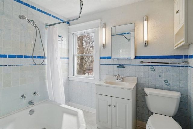 bathroom featuring wainscoting, toilet, shower / tub combo with curtain, vanity, and tile walls