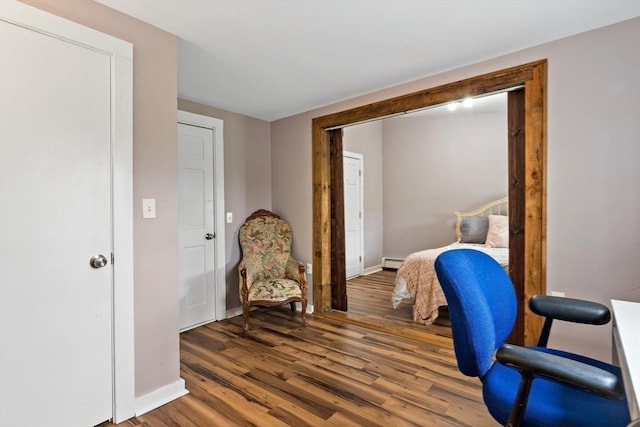 office space with baseboards, baseboard heating, and wood finished floors