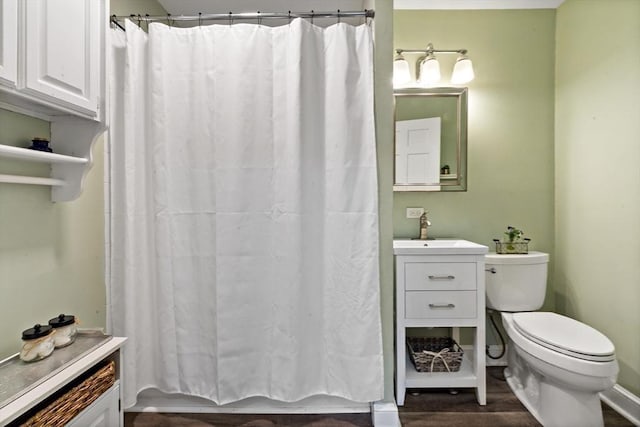 bathroom with vanity, curtained shower, toilet, and wood finished floors