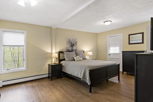 bedroom featuring wood finished floors and baseboard heating