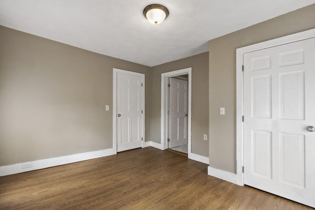 unfurnished bedroom with baseboards and wood finished floors