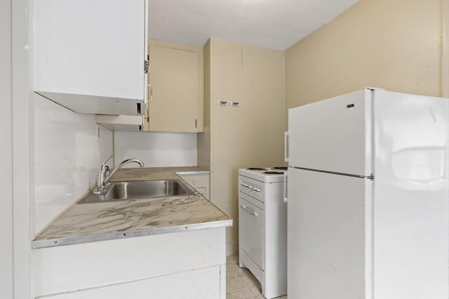 kitchen featuring cream cabinets, a sink, light countertops, washer / dryer, and white appliances