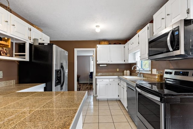 kitchen with a sink, appliances with stainless steel finishes, and white cabinets