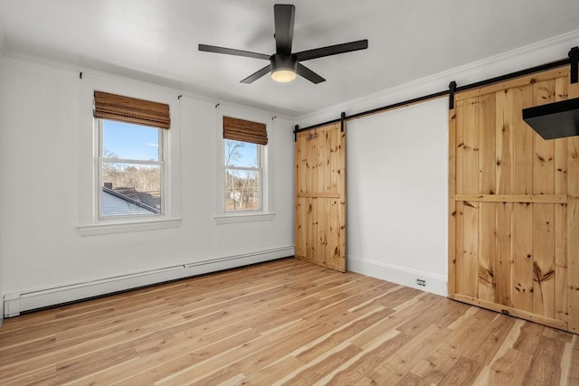 unfurnished bedroom featuring crown molding, light wood finished floors, baseboard heating, and a barn door