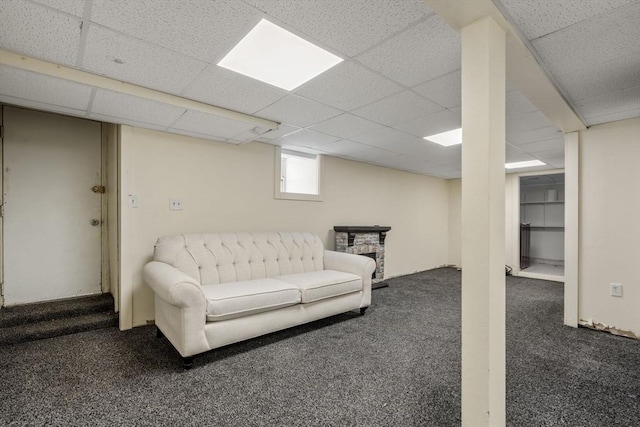 living room featuring a drop ceiling and carpet