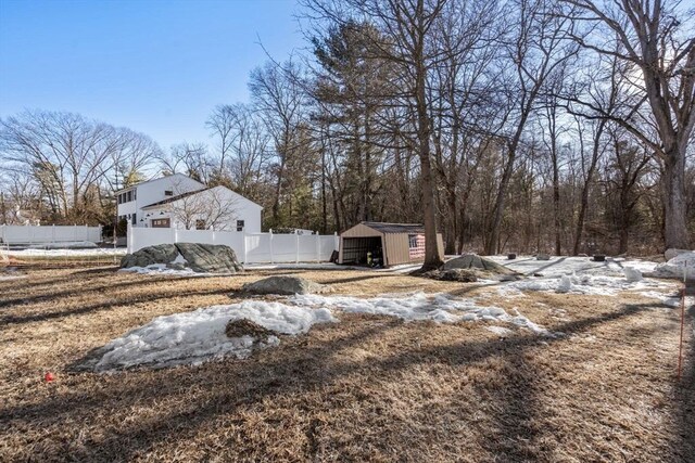 view of yard featuring a detached garage, fence, and an outdoor structure