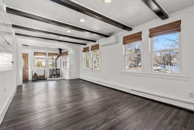 unfurnished living room featuring dark wood finished floors, baseboard heating, a wood stove, a wall mounted air conditioner, and beamed ceiling