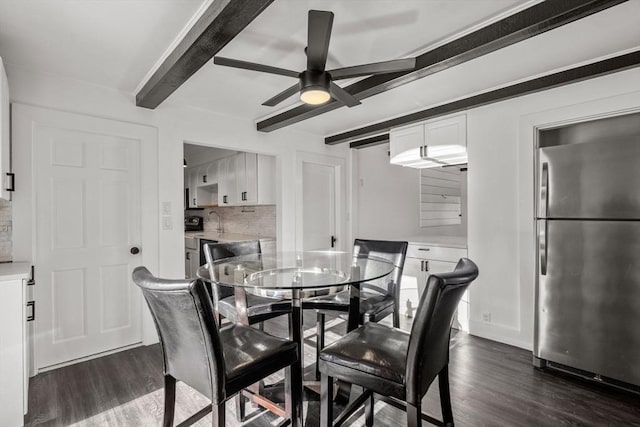 dining room featuring dark wood-type flooring, beam ceiling, and ceiling fan