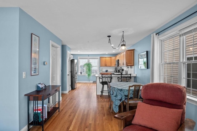 living room with baseboards, recessed lighting, and light wood-style flooring