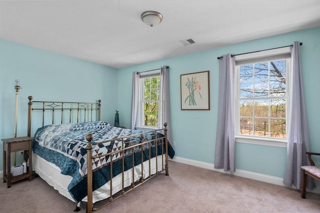 carpeted bedroom featuring baseboards and visible vents
