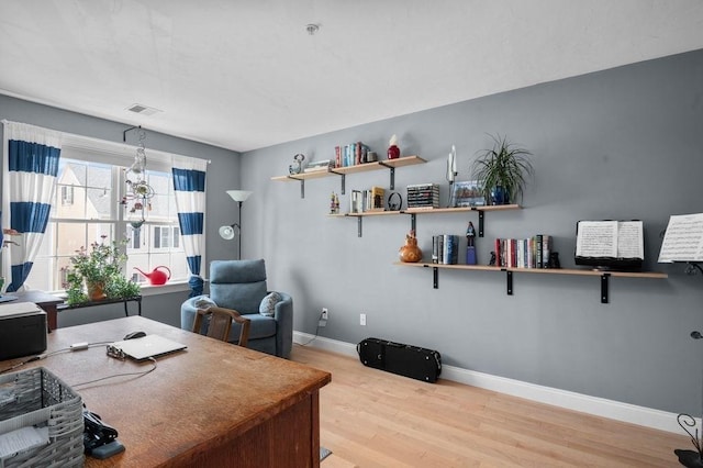 office with baseboards, light wood finished floors, and visible vents