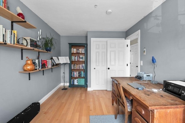 office space featuring baseboards and light wood-style flooring