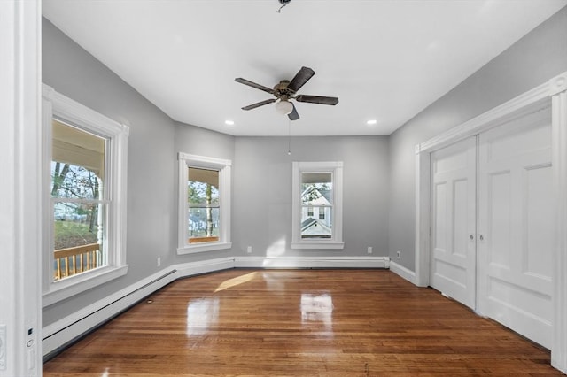 unfurnished bedroom with recessed lighting, baseboards, baseboard heating, and wood finished floors